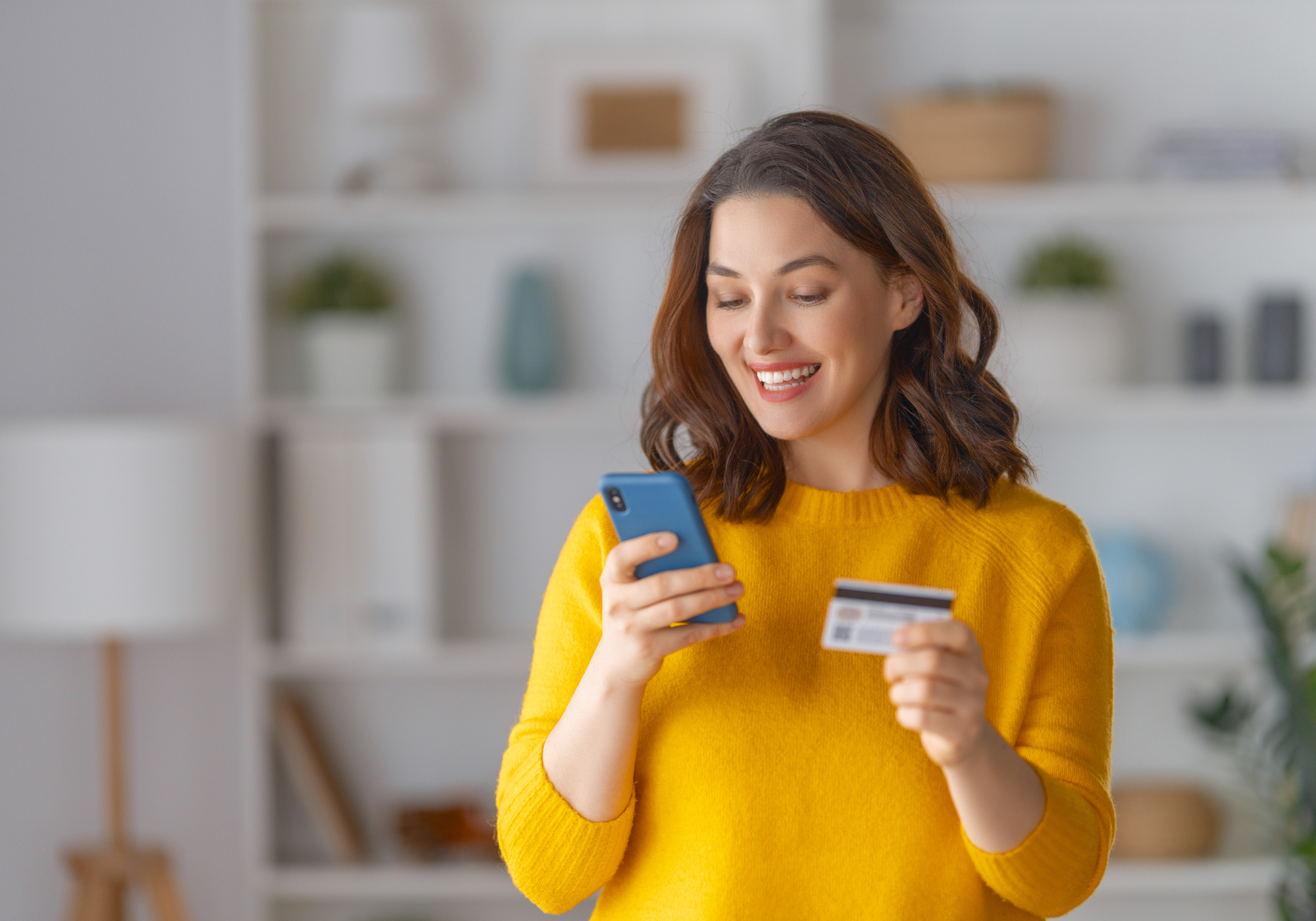 Woman reviewing credit card rate online while smiling.
