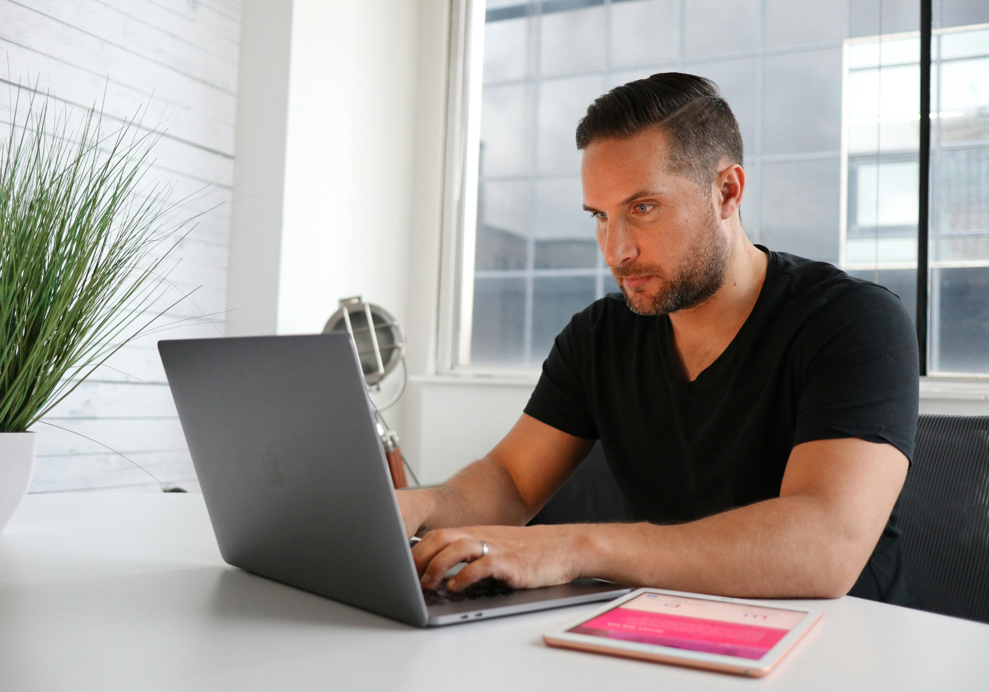 Man reviewing The Police Credit Union savings-secured loan on a laptop to build credit and improve financial stability.