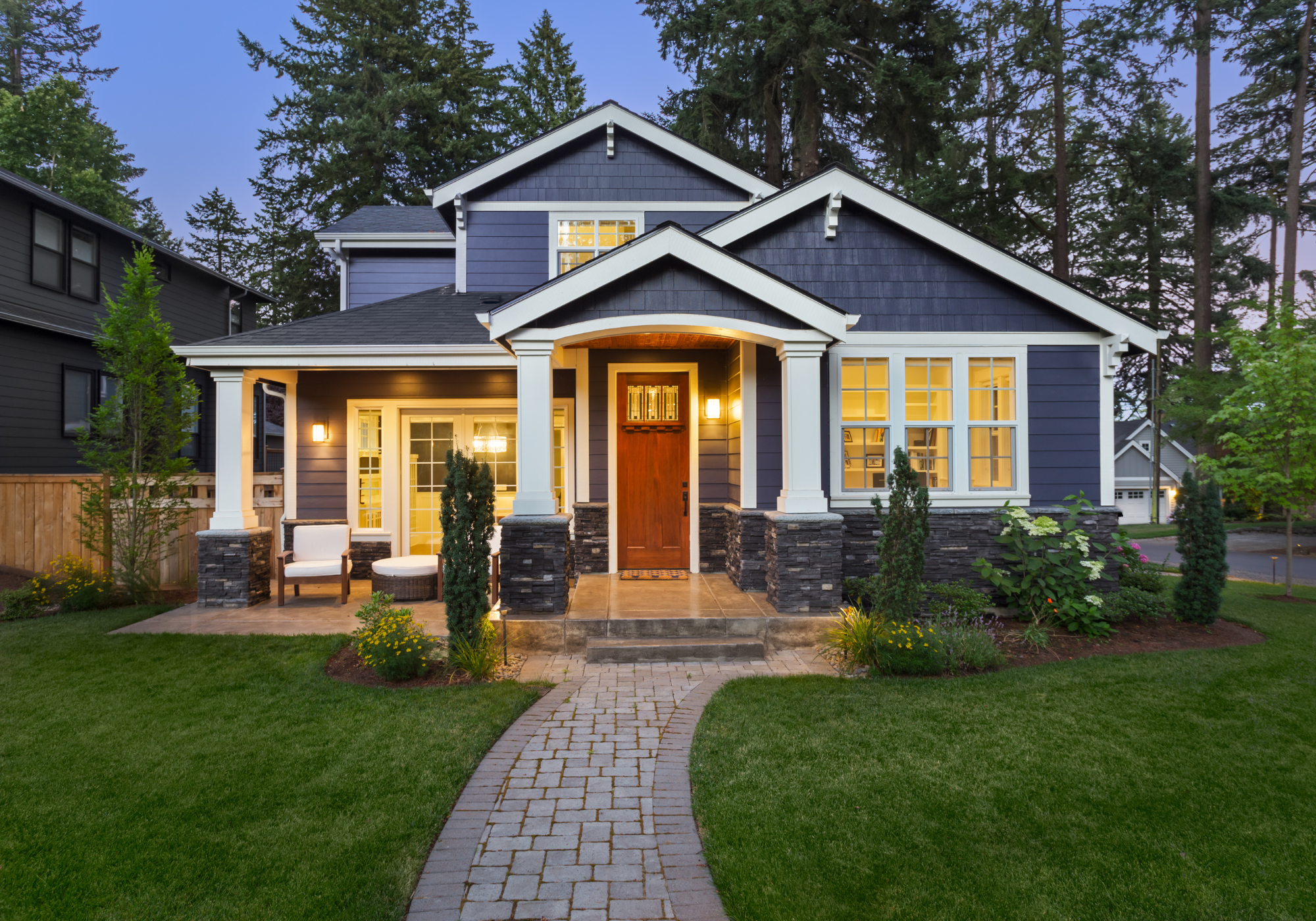 A well-maintained home with a lush green lawn at sunset, symbolizing seasonal home care and energy-efficient living.