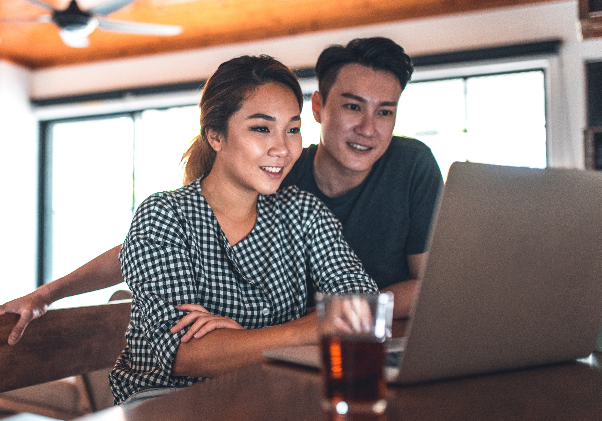 Couple reviewing their finances on a laptop and creating a household budget together.